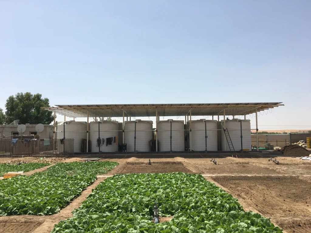 Water storage tanks beside a solar array